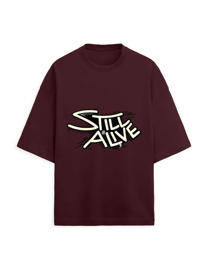Maroon oversized terry tee with bold 'Still Alive' graffiti-style typography chest print
