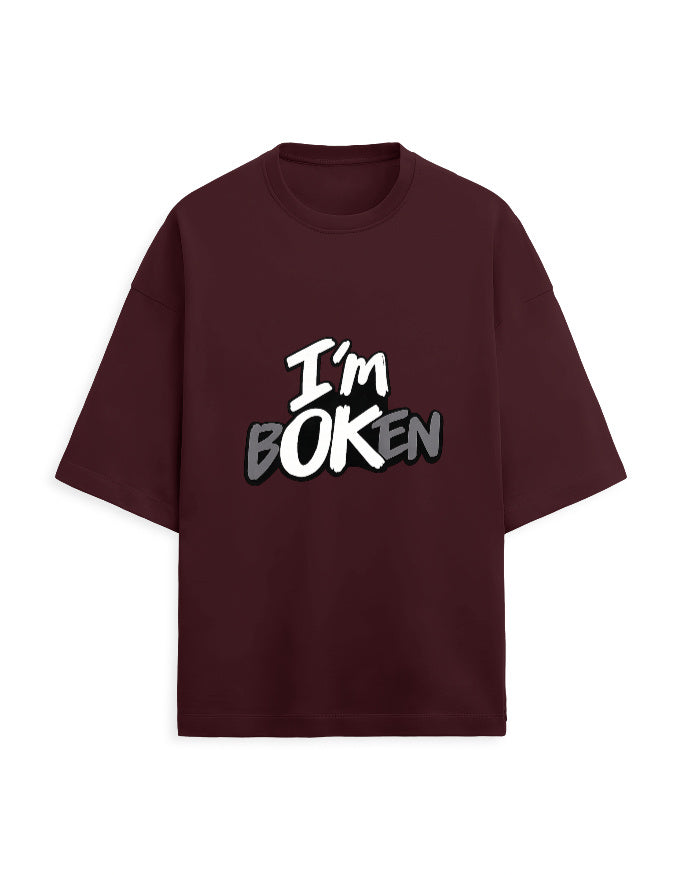 Flat-lay front view of white oversized graphic tee with "I'm bOKEN" print