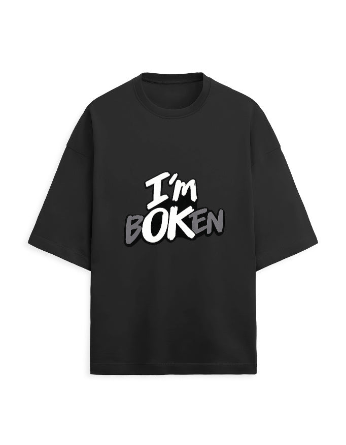 Close-up front view of white oversized tee showing "I'm bOKEN" graphic print detail
