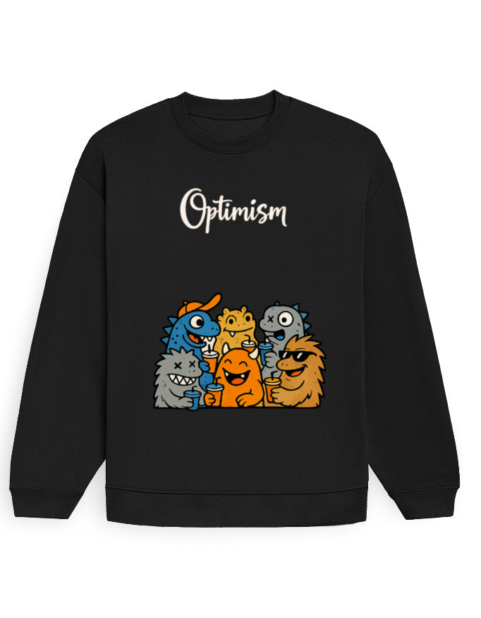 Black oversized sweatshirt with white 'Optimism' script text and a colorful cartoon monster group graphic printed on the front