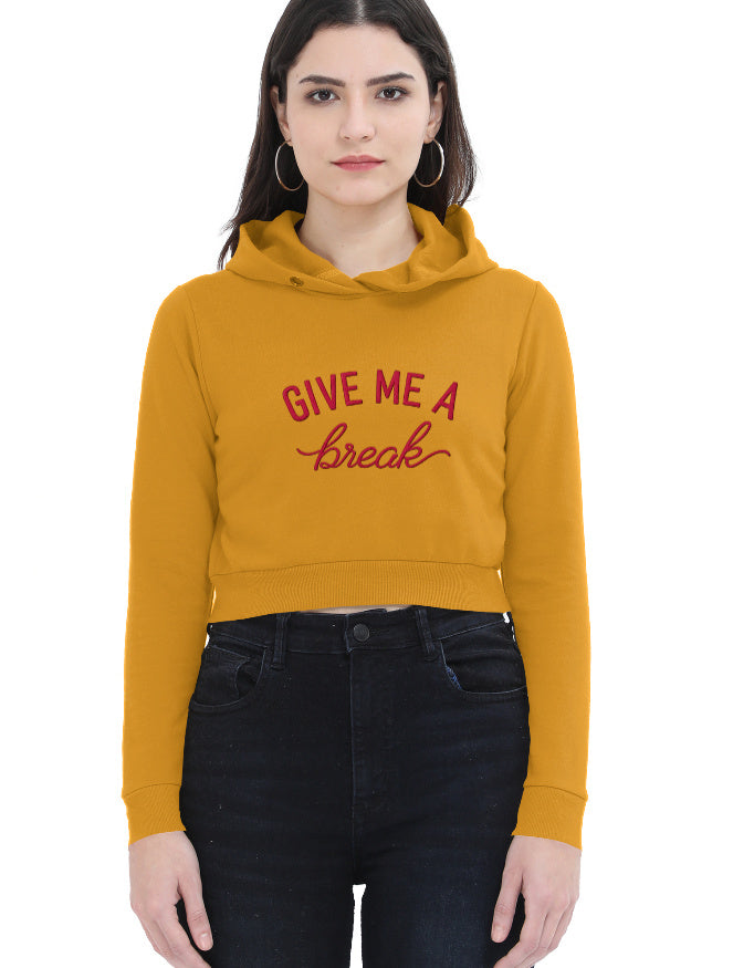Model wearing black cropped hoodie for women with red 'Give Me A Break' script graphic on the front