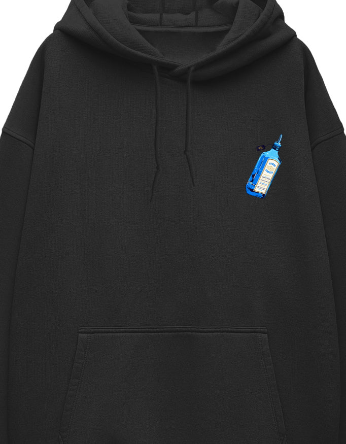 Small illustrated blue glass bottle graphic with a cream label printed on the left chest of a white unisex oversized hoodie.